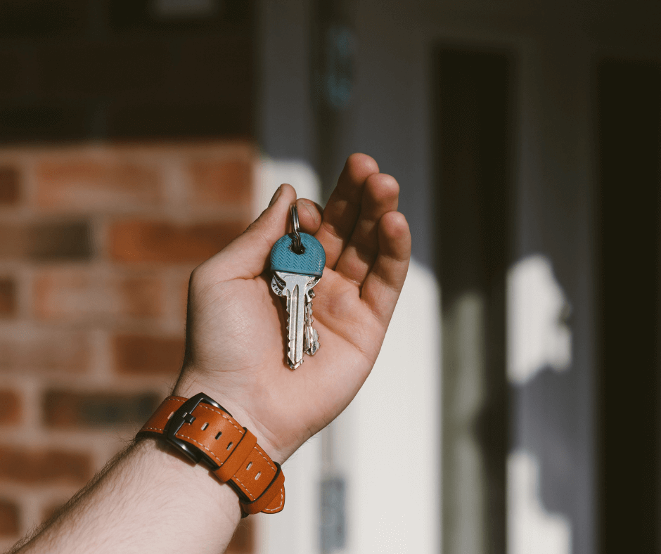 A person holding a key to a house.