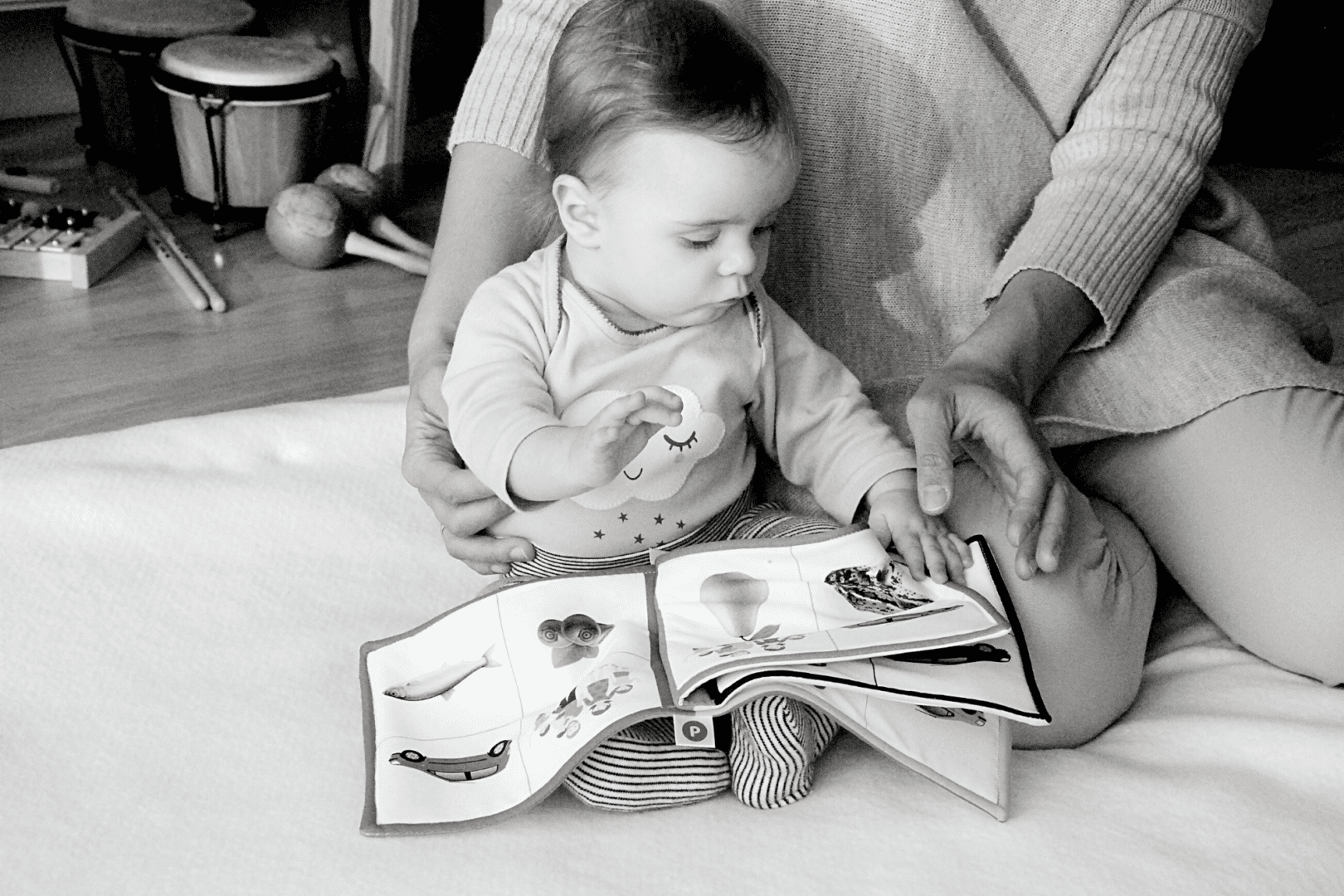 A woman reading a book to a baby.