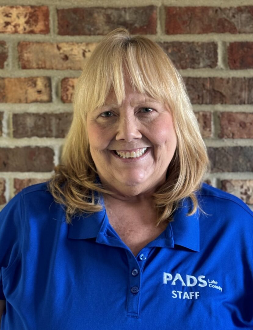 Smiling woman in blue PADS staff shirt.